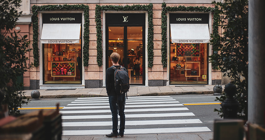 consumers dude in front of Louis Vuitton store feature