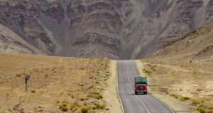 freight consortium trucker on lonely road feature